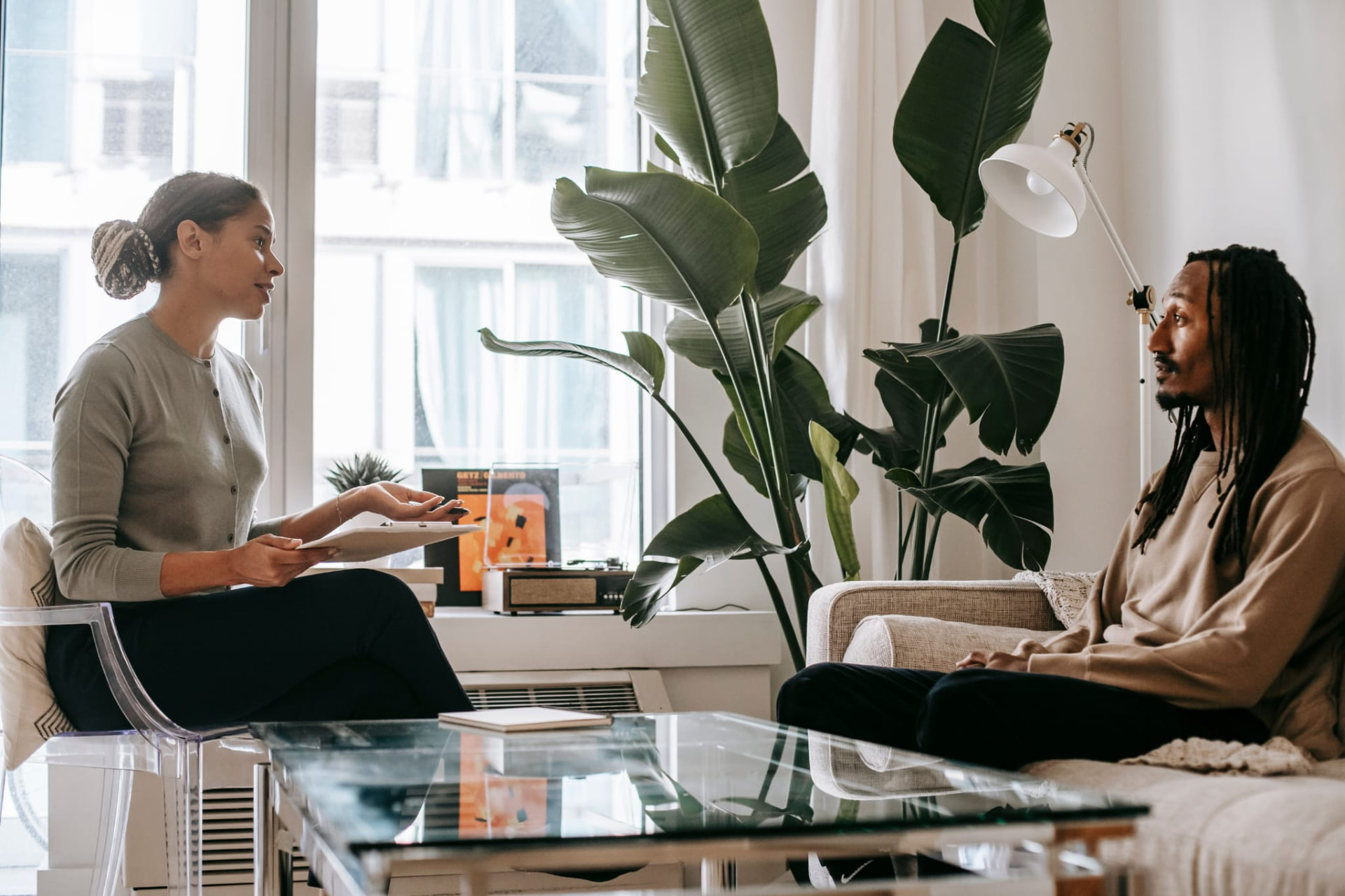 A psychiatric care provider talking with a patient during a relaxed consultation at home